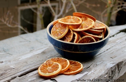Thin, crispy dehydrated orange slices with bright orange color, showing a chewy texture and concentrated citrus flavor, perfect as a healthy snack or dessert topping.”