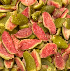 Thin, chewy dehydrated guava slices with a pinkish-orange color, showing natural sweet-tangy flavor, perfect as a healthy snack or dessert topping.”